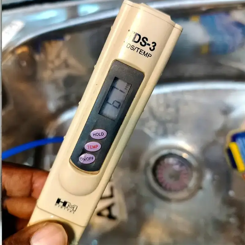 RO technician checking water TDS level at home in Delhi NCR